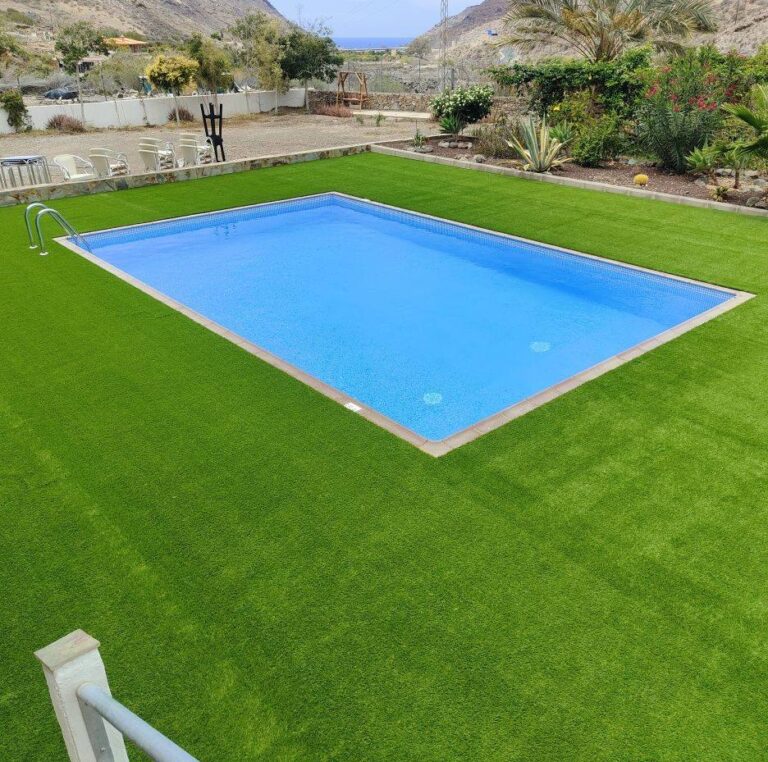 Césped artificial instalado alrededor de una piscina rectangular