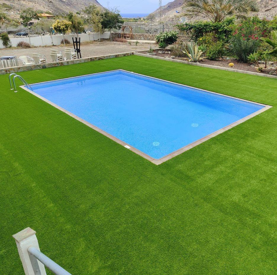 Césped artificial instalado alrededor de una piscina rectangular