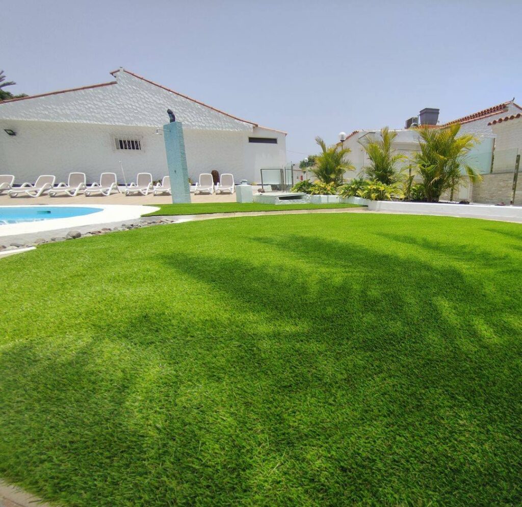 Zona de piscina con tumbonas sobre césped artificial