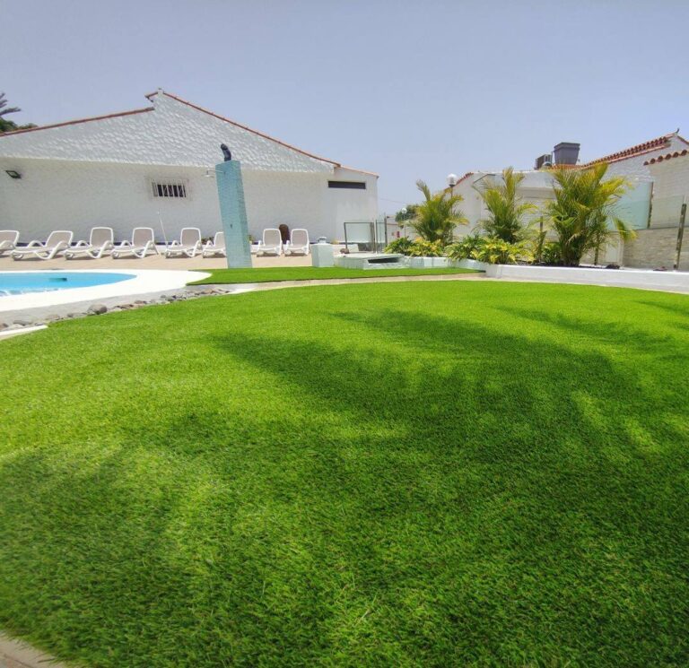 Zona de piscina con tumbonas sobre césped artificial
